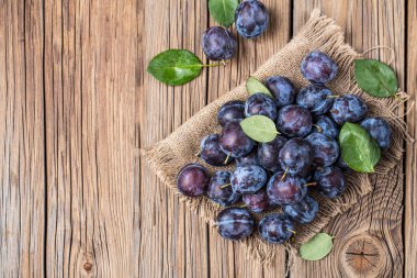 Taze yaprak yeşil rustik tablo hasır sepet ve hlaf erik erik yığını.