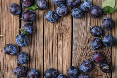 Taze yaprak yeşil rustik tablo hasır sepet ve hlaf erik erik yığını.