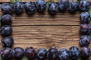 Taze yaprak yeşil rustik tablo hasır sepet ve hlaf erik erik yığını.