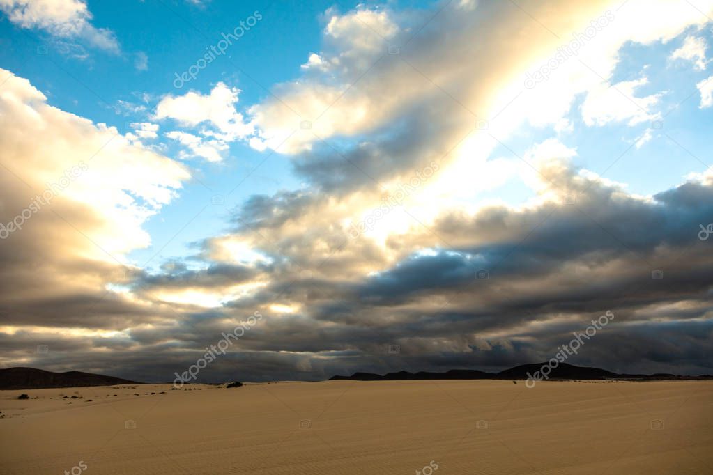 beautiful landscape with sand dunes and cloudy sky at Corralejo Natural Park, Fuerteventura, Canary Islands, Spain