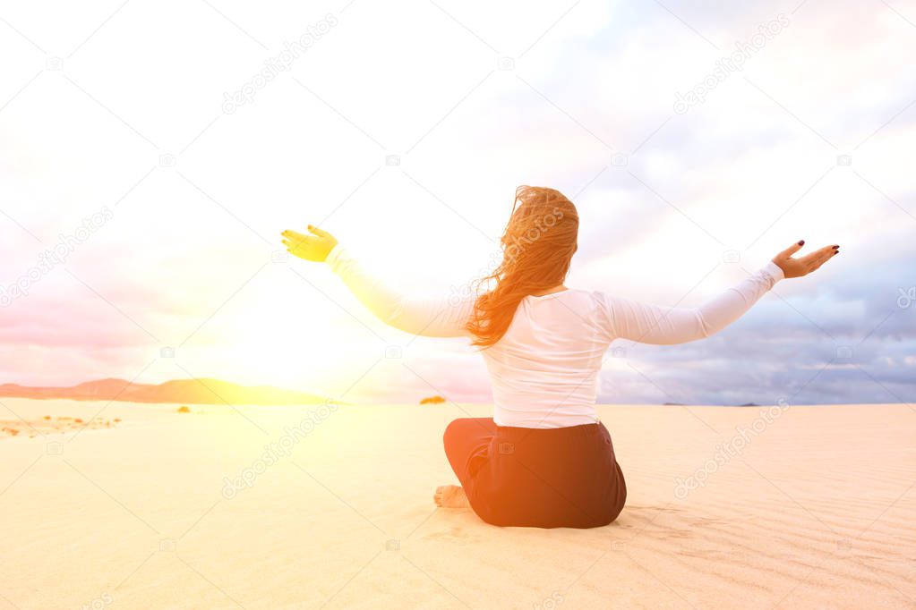 back view of young woman meditating in desert on Canary Islands, Spain. Relax concept