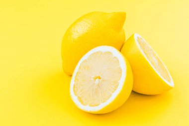 taze olgun tüm ve yarıya limon sarı arka plan üzerinde görmek 