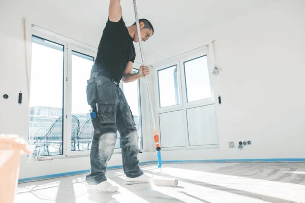 Lavoratore Mettendo Primer Con Rullo Sul Pavimento Cemento Durante Ristrutturazione — Foto Stock