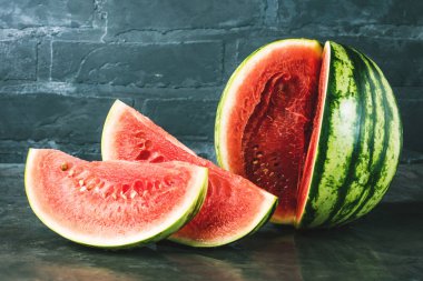 Sulu karpuz gri yüzeyi ve tuğla duvar arka plan üzerinde görmek
