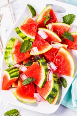 Üstten Görünüm taze sulu buz küpleri ile karpuz beyaz tabağa dilimlenmiş
