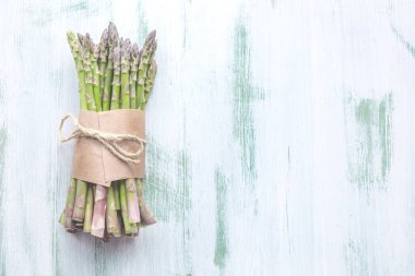 Üstten Görünüm taze çiğ yeşil kuşkonmaz gri arka plan üzerinde bağlı.  