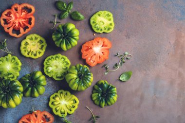 taze yeşil ve kırmızı domates yaprakları ve otlar ile üstten görünüm gri yüzeyi  