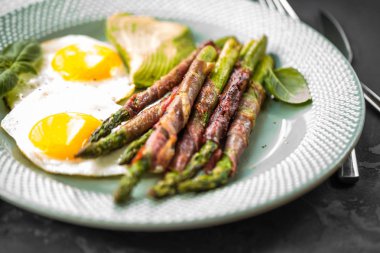 pastırmalı kızarmış yumurta plaka üzerinde sarılı kuşkonmaz yakından görmek