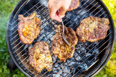 kömür ızgarada biftek hazırlanması ve çatal tutan kişinin kısmi Üstten Görünüm
