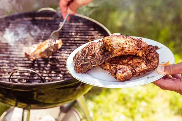 Bijgesneden Schot Van Persoon Holding Plaat Koken Steaks Houtskool Barbecue — Stockfoto