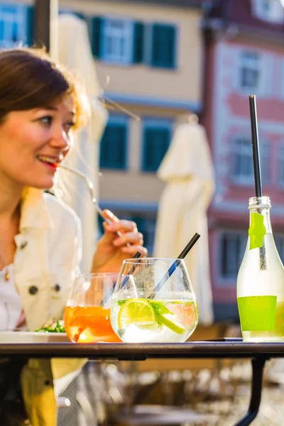 微笑的年轻女子在户外咖啡馆享用美味的饭菜和鸡尾酒 — 图库照片