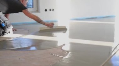 İşçi astarı beton zemine koyuyor. Ev yapım aşamasında. 