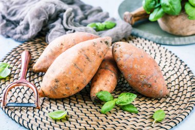 yakın çekim görünümü taze yacon veya Perulu zemin elma ve fesleğen yaprakları rustik masa tatlı, patates, tatlı patates