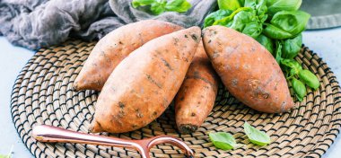 yakın çekim görünümü taze yacon veya Perulu zemin elma ve fesleğen yaprakları rustik masa tatlı, patates, tatlı patates