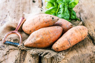 yakın çekim görünümü fesleğen ve taze sağlıklı yacon yaprakları rustik ahşap masa tatlı, patates, tatlı patates