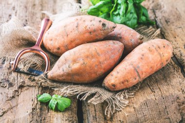 yakın çekim görünümü taze yacon veya Perulu zemin elma ve fesleğen yaprakları rustik ahşap masa tatlı, patates, tatlı patates