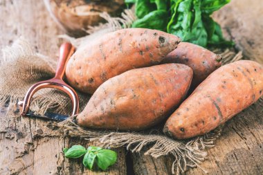 yakın çekim görünümü taze yacon veya Perulu zemin elma ve fesleğen yaprakları rustik ahşap masa tatlı, patates, tatlı patates