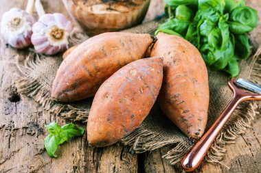 taze yacon veya Perulu zemin elma, sarımsak ve fesleğen yaprakları rustik ahşap masa tatlı, patates, tatlı patates