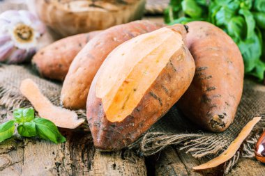 taze yacon veya Perulu zemin elma, sarımsak ve fesleğen yakından görmek yaprakları rustik ahşap masa tatlı, patates, tatlı patates