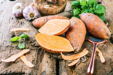 taze yacon veya Perulu zemin elma, sarımsak ve fesleğen yakından görmek yaprakları rustik ahşap masa tatlı, patates, tatlı patates