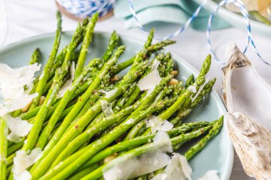 Taze yeşil kuşkonmaz dalları ve buzlu istiridye.