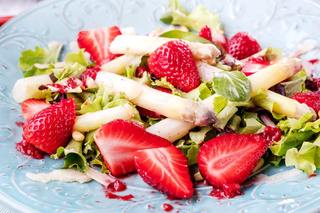 close-up view of fresh healthy salad with strawberries and asparagus on table