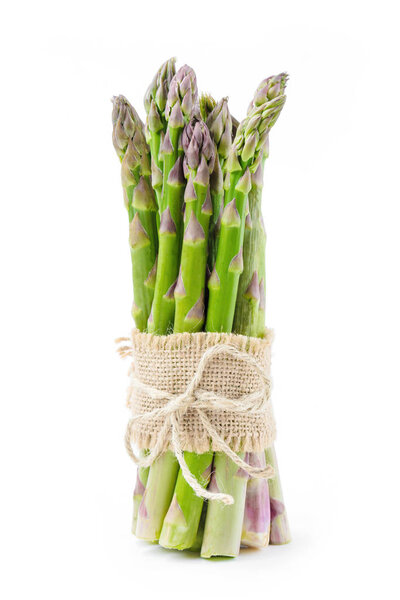bunch of fresh green tied asparagus isolated on white, close-up  