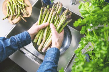 yüksek açı çekim kırpılmış taze olgun kuşkonmaz mutfak lavaboda yıkama biri görüntülemek