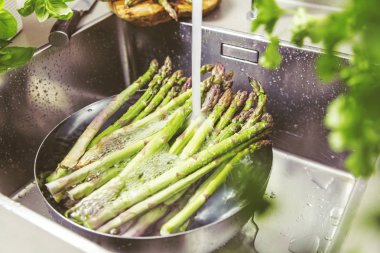 mutfak lavaboda kevgir içinde taze olgun sağlıklı kuşkonmaz