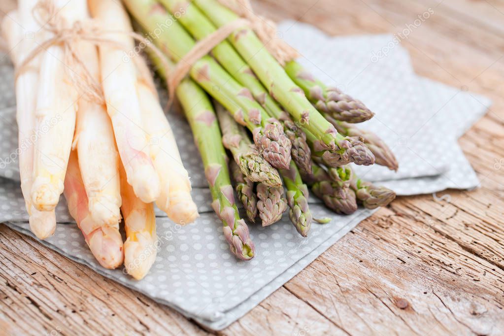 close-up view of fresh ripe green and white asparagus on wooden table  