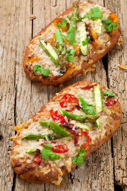 güzel küçük pizza sebze ile ahşap masa üzerinde görmek