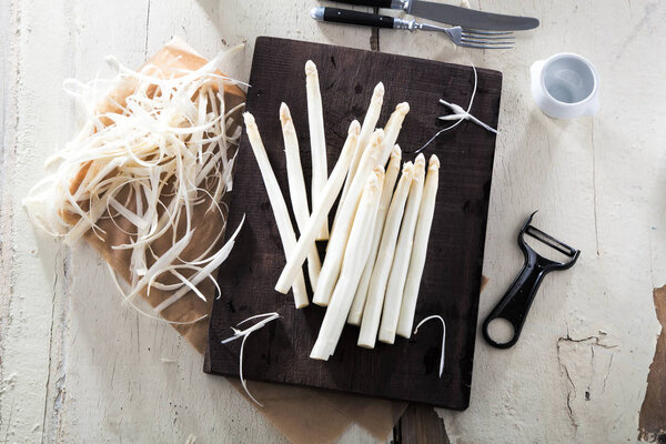 вид на вкусную белоснежную спаржу на деревянной доске
 