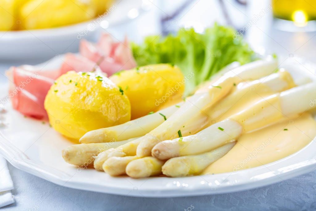 close-up view of gourmet dish with asparagus, potatoes and ham on table