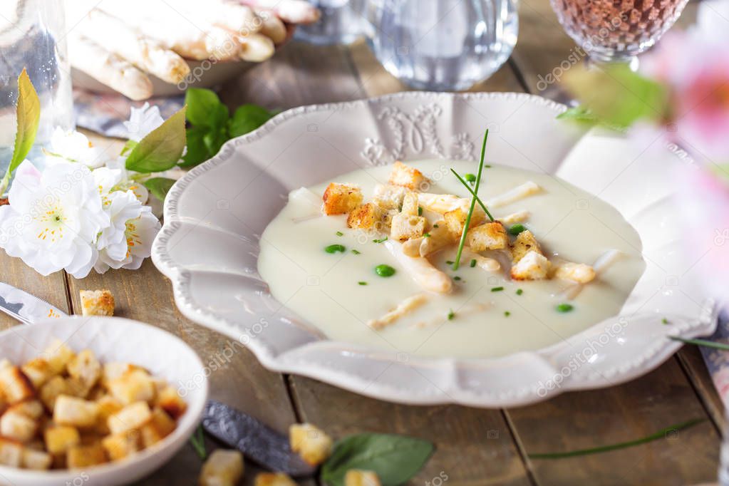 close-up view of plate with delicious creamy asparagus soup flavoured with chicken stock, sour cream, croutons and basil