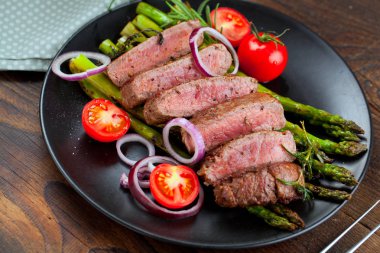 yakından görmek lezzetli Barbekü T-bone biftek dilimlenmiş yeşil kuşkonmaz ve sebze ile