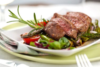 yakından görmek lezzetli Barbekü T-bone biftek dilimlenmiş yeşil kuşkonmaz ve sebze ile