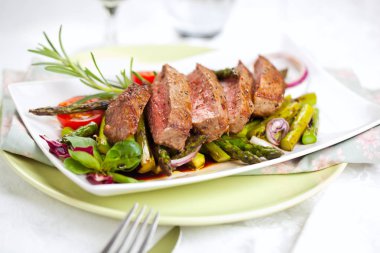 yakından görmek lezzetli Barbekü T-bone biftek dilimlenmiş yeşil kuşkonmaz ve sebze ile