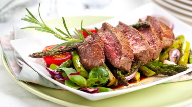 yakından görmek lezzetli Barbekü T-bone biftek dilimlenmiş yeşil kuşkonmaz ve sebze ile