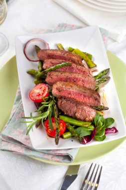 yakından görmek lezzetli Barbekü T-bone biftek dilimlenmiş yeşil kuşkonmaz ve sebze ile