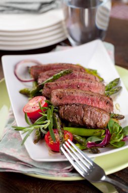 yakından görmek lezzetli Barbekü T-bone biftek dilimlenmiş yeşil kuşkonmaz ve sebze ile