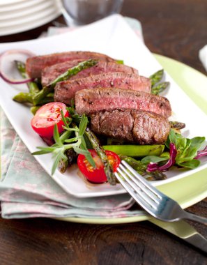 yakından görmek lezzetli Barbekü T-bone biftek dilimlenmiş yeşil kuşkonmaz ve sebze ile