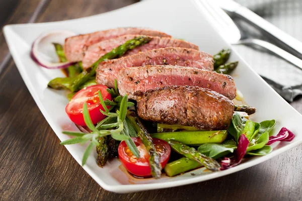 Close View Delicious Sliced Steak Grilled Asparagus Tomatoes Herbs Plate — Stock Photo, Image