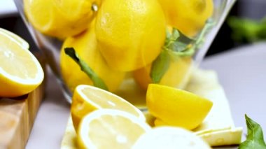 taze sulu bütün ve yarıya limon, yeşil yaprakları ve cam kase yakından görmek tablo