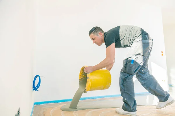 Werknemer Die Werkt Met Zelfnivellerende Cement Mortel Tijdens Vloerbedekking — Stockfoto
