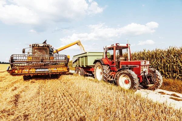 agricultural machine for harvesting grain crops and tractor on farm field