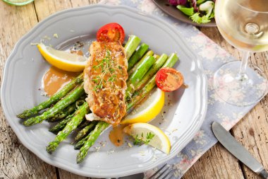 kuşkonmaz, domates, limon ve soslu gurme ızgara somon bifteğinin yakın çekim görünümü  