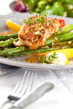 kuşkonmaz, domates, limon ve soslu gurme ızgara somon bifteğinin yakın çekim görünümü  