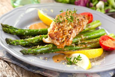 kuşkonmaz, domates ve soslu gurme ızgara somon bifteğinin yakın çekim görünümü  