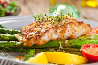 kuşkonmaz, domates ve soslu gurme ızgara somon bifteğinin yakın çekim görünümü 