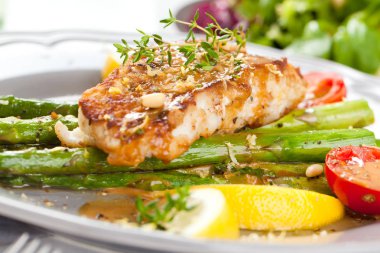 kuşkonmaz ve soslu gurme ızgara somon bifteğinin yakın çekim görünümü